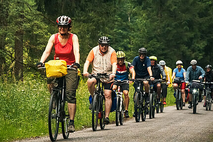 Gruppe von Menschen auf Fahrrädern im Wald