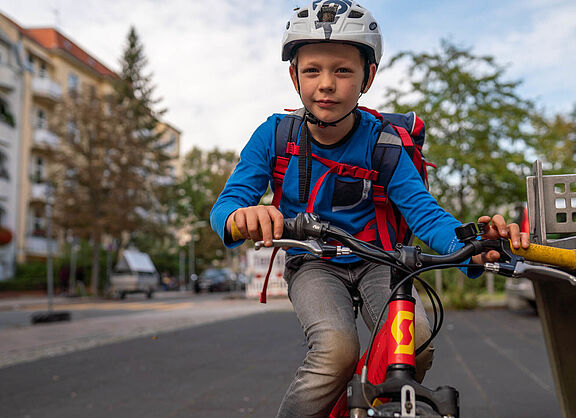 Junge mit Schulranzen auf dem Fahrrad