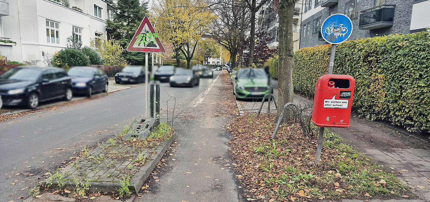 Die Klaerchenstraße: Parkende Kfz auf beiden Seiten, breite Fahrspur für Kfz, dafür kaum Platz für Fuß- und Radverkehr.