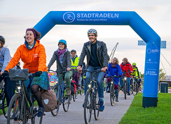 Gruppe Radfahrender fährt durch einen Torbogen