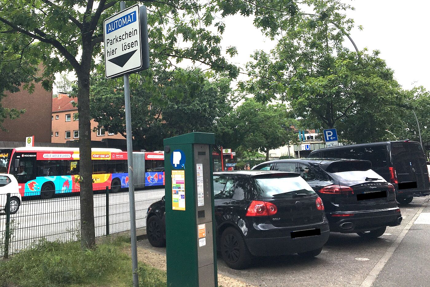 Einige Autos stehen auf Schrägparkplätzen. An einem Automaten steht das Verkehrszeichen "Automat - Parkschein hier lösen"