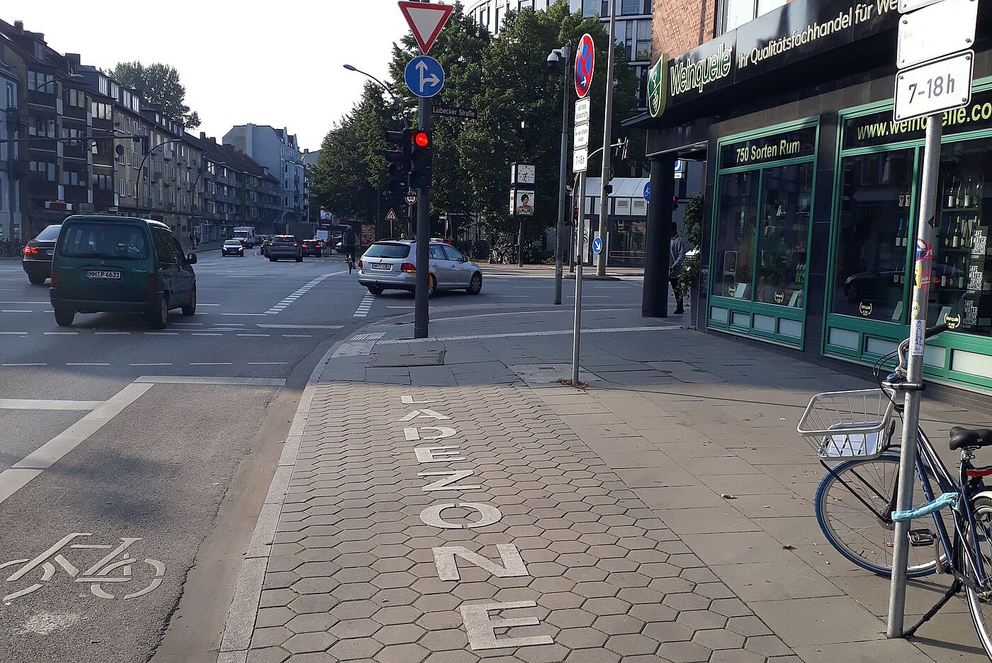 Neben dem Radfahrstreifen befindet sich eine freie Ladezone. Am Verkehrszeichenmast ist ein Fahrrad angeschlossen.