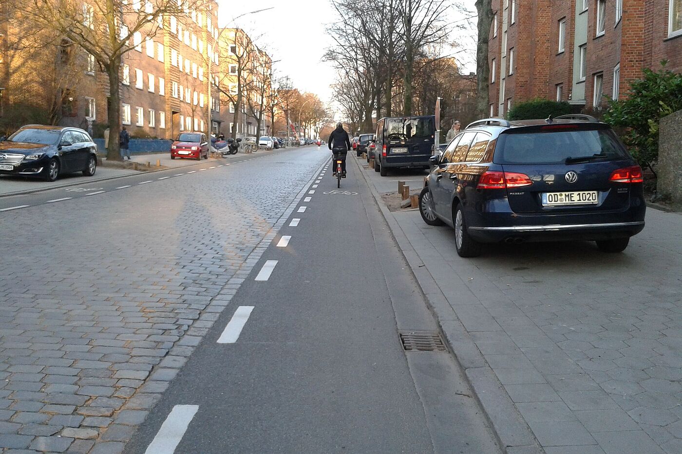 nach dem Umbau: Radfahrer*innen fahren im Sichtfeld der Autofahrer*innen auf den Schutzstreifen aus Asphalt.