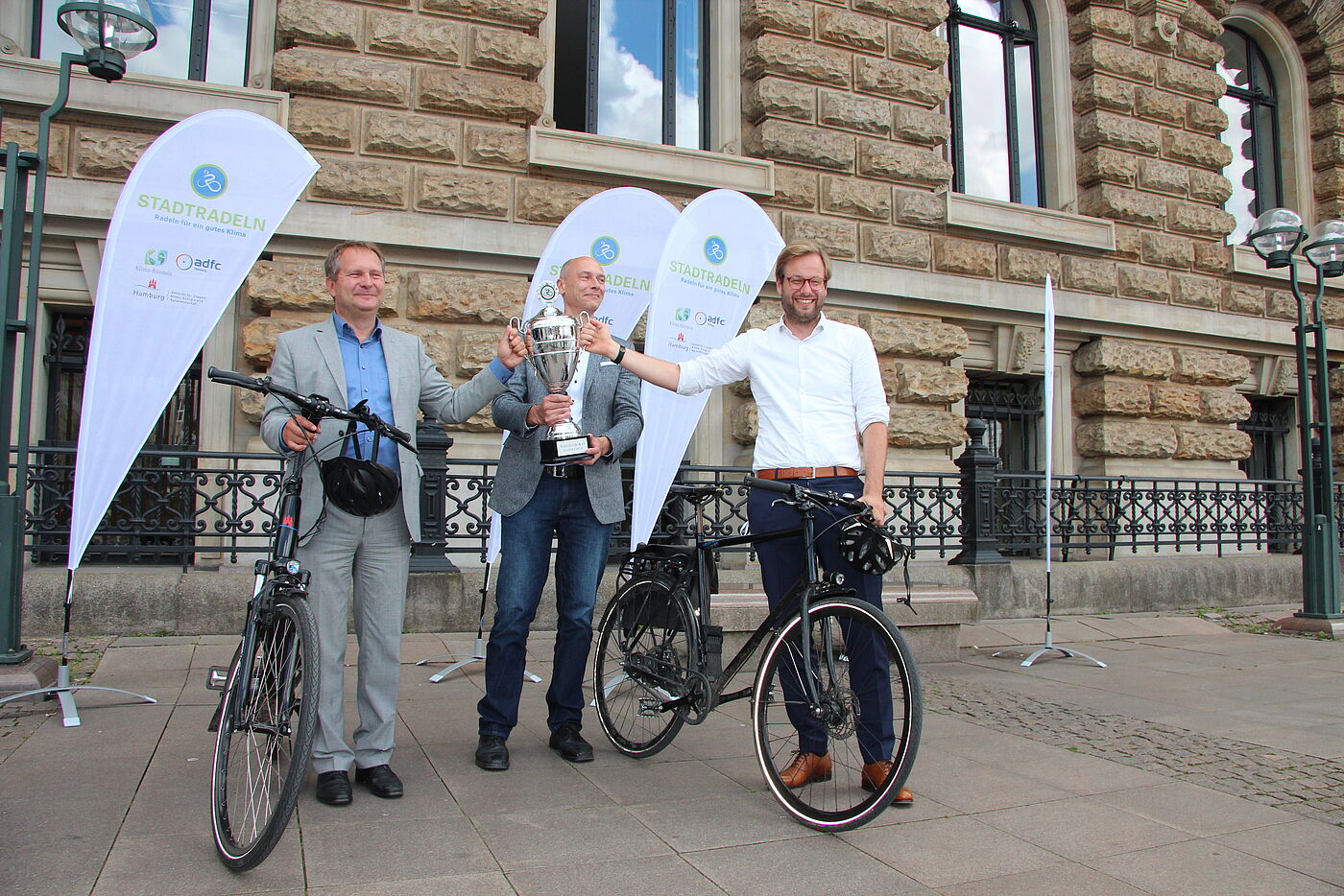 Umweltsenator, Verkehrssenator u. ADFC-Landesvorsitzender halten Pokal