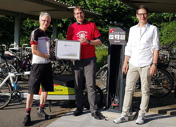 Zertifikatsübergabe auf dem Campus Bahrenfeld, Thomas, Lütke (ADFC, an Prof. Dr. Tilo Böhmann, Vizepräsident der UHH für Forschung, und Erik Gawron.