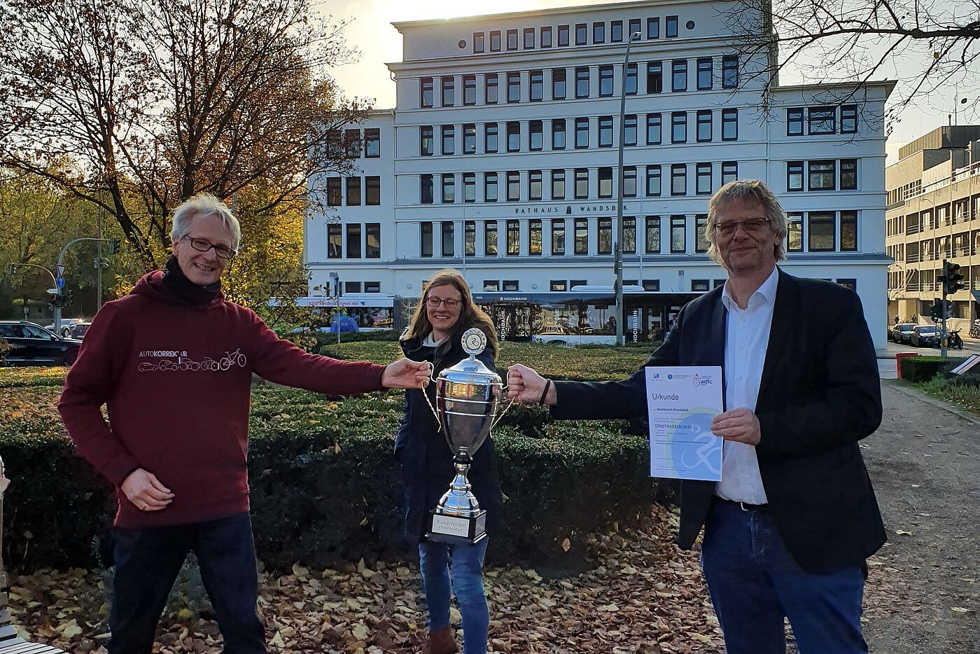 Drei Personen halten Wanderpokal für Stadtradeln 