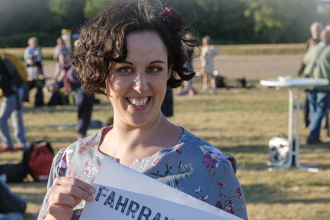 Samina Mir mit einem Schild"Fahrbahnfahrerin"