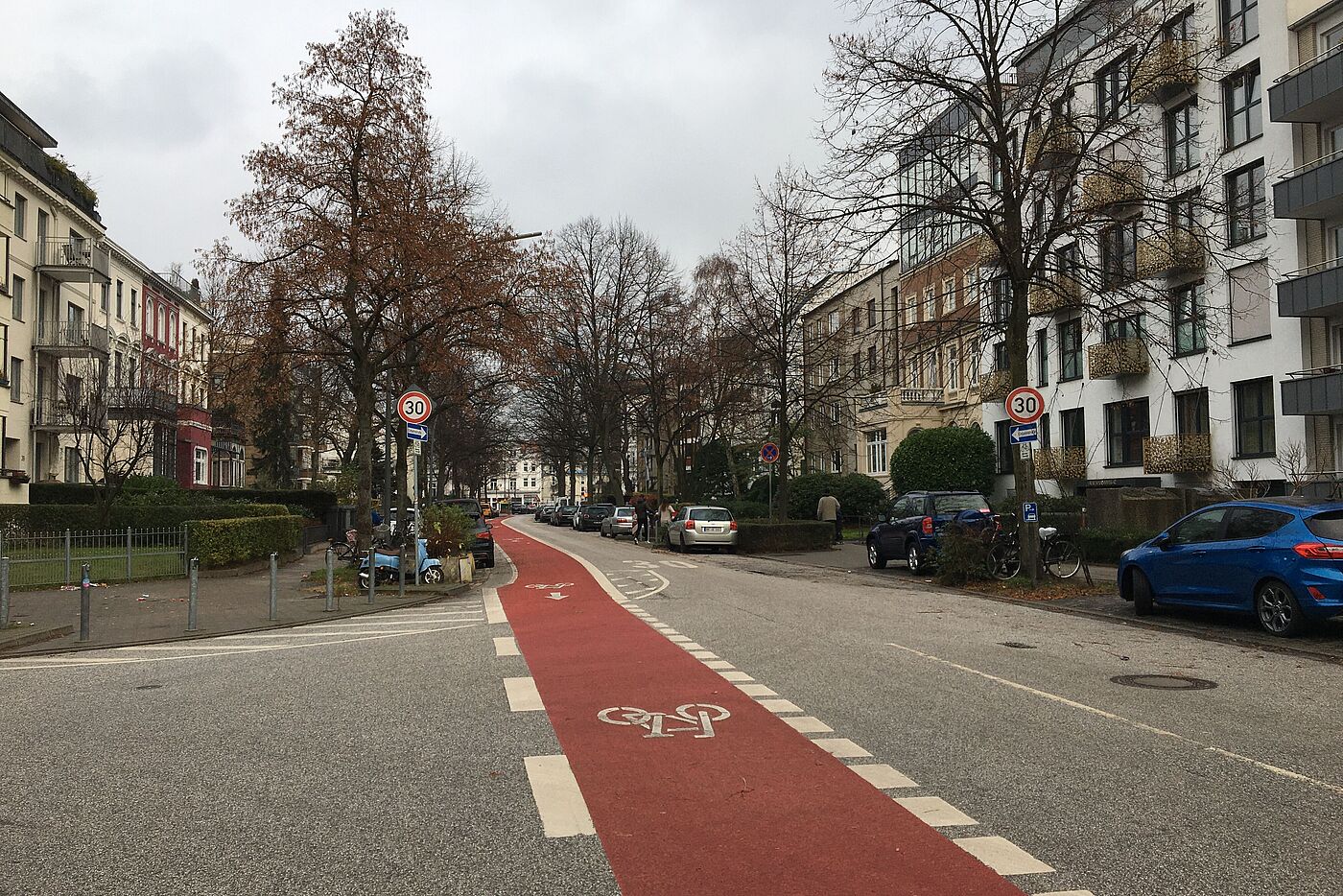 Die Straße Graumannsweg mit beidseitiger Blockbebauung, gepakrten Autos beidseits, Tempo-30-Anordnung und Radfahrstreifen Richtung Innenstadt