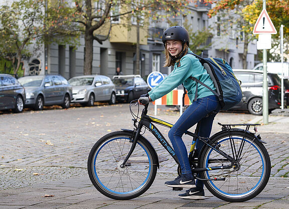 Ein Mädchen auf dem Fahrrad lächeltin die Kamera