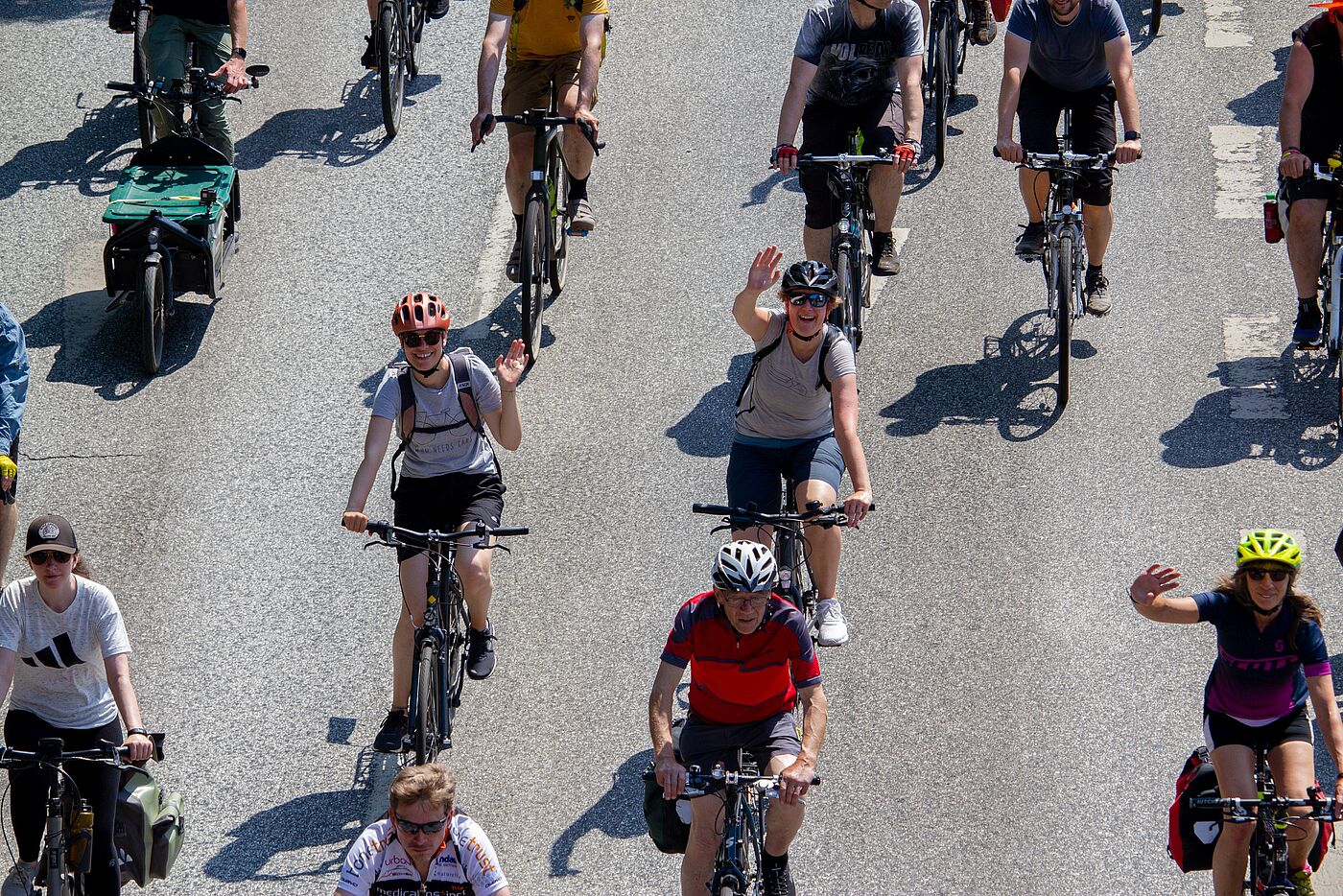 Teilnehmende bei der Sternfahrt winken in die Kamera