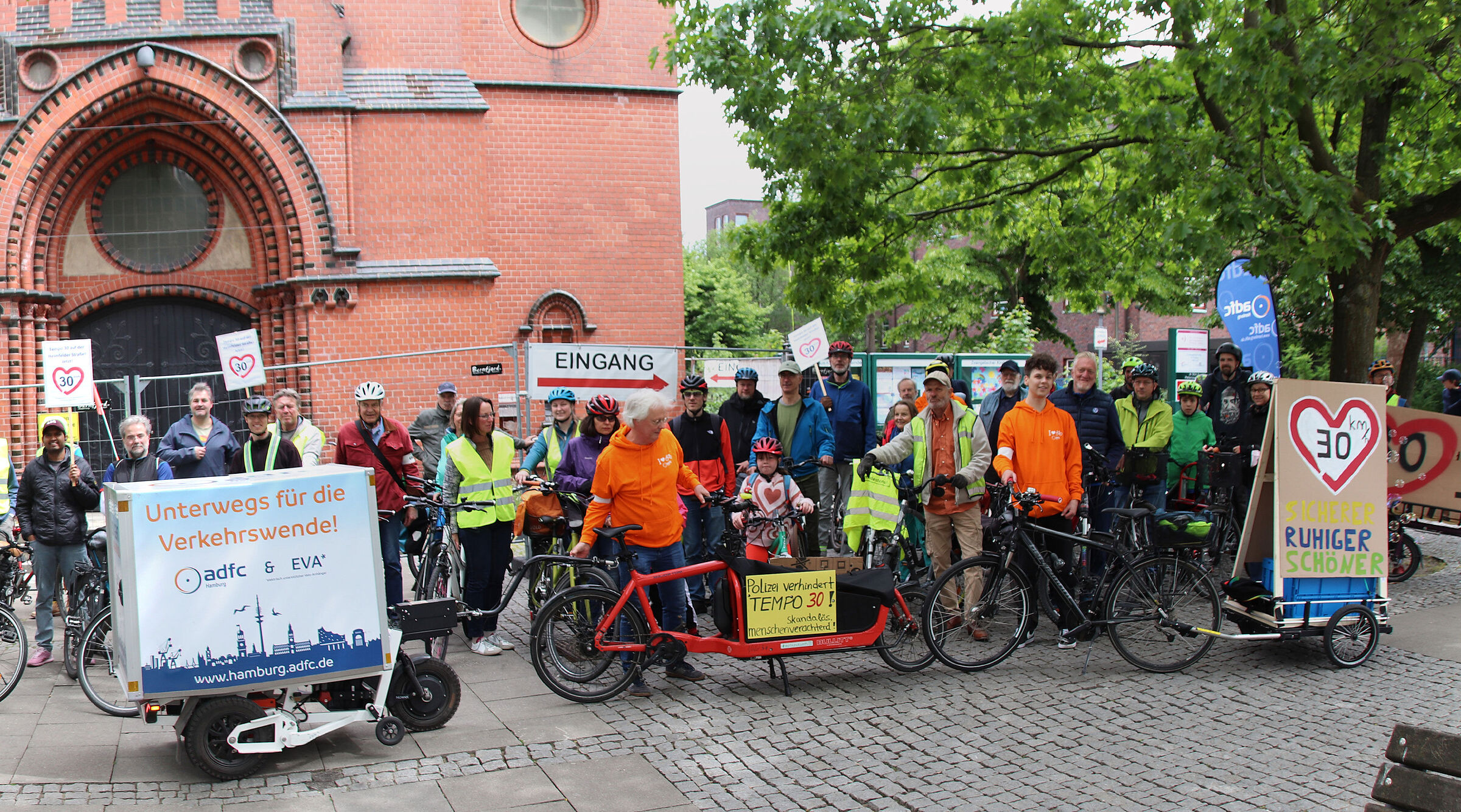 Demoteilnehmer*innen haben sich vor der Kirche in Hamburger Stadtteil Heimfeld versammelt 
