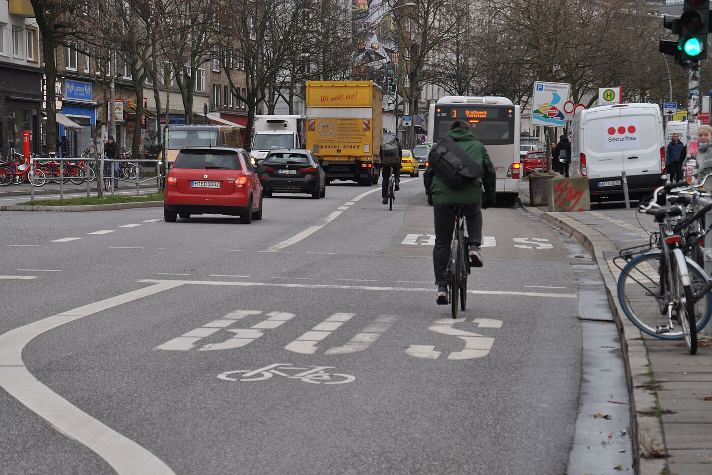 Rechts verläuft eine breite Fahrspur mit der Aufschrift "Bus" und dem Fahrradpiktogramm. Links daneben verläuft eine Fahrspur für den motorisierten Individualverkehr.