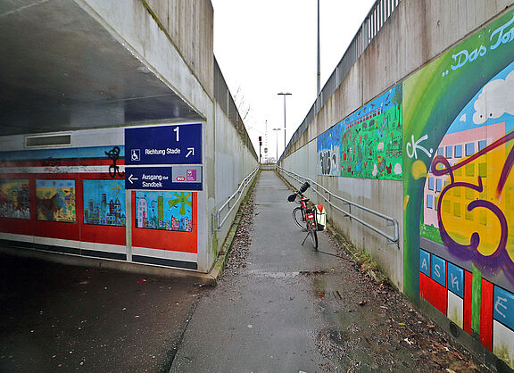 Das Bild zeigt die Unterführung der Gleisanlagen am Bahnhof Fischbek. Ein abgestelltes Fahrrad zeigt, wie eng es dort ist.