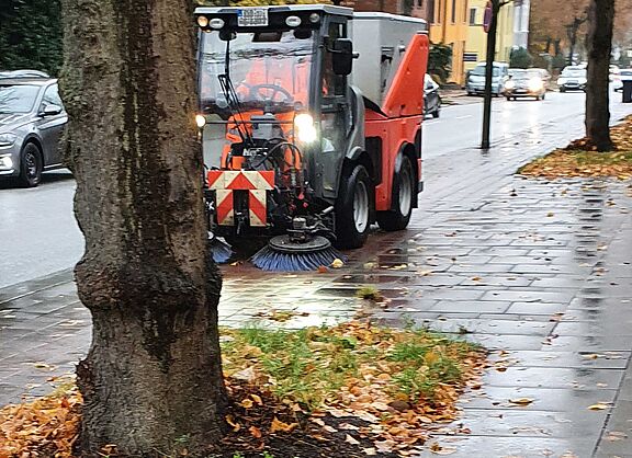 Die Stadtreinigung bei der Arbeit mit Kehrfahrzeug auf einem Radweg