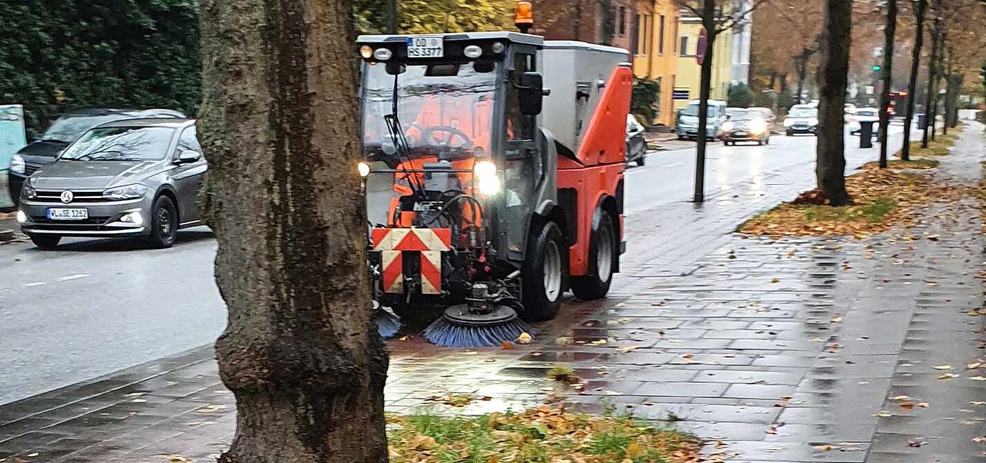 Die Stadtreinigung bei der Arbeit mit Kehrfahrzeug auf einem Radweg