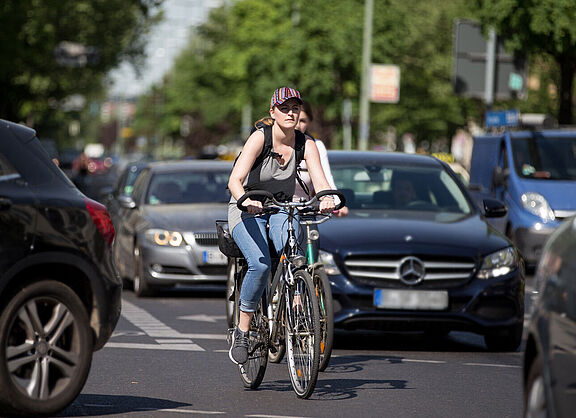 Radfahrerein zwischen Autos