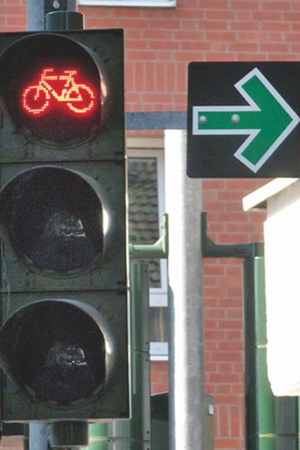 Ampel mit einem roten Fahrradsymbol und einem angebrachten Grünpfeil Ampel mit einem roten Fahrradsymbol und einem angebrachten Grünpfeil