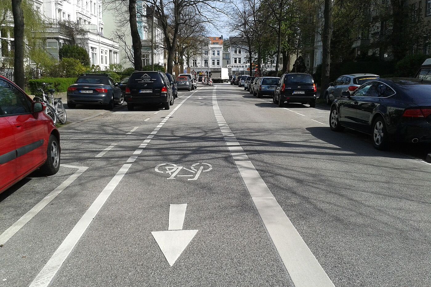 Graumannsweg. Einseitiger Radfahrstreifen gegenläufig zur Einbahnstraße. In der anderen Richtung fahren die Radfahrenden im Mischverkehr (eingerichtet April 2015). Der Streifen wurde oft von Autofahrer*innen regelwidrig zum Überholen genutzt. In 2020 wurde er deshalb rot eingefärbt.