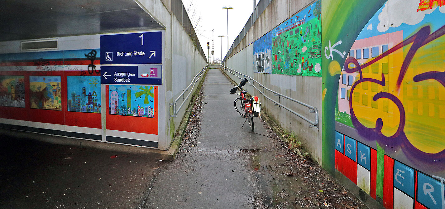 Das Bild zeigt die Unterführung der Gleisanlagen am Bahnhof Fischbek. Ein abgestelltes Fahrrad zeigt, wie eng es dort ist.