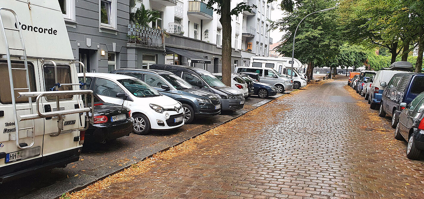 Die OSterbekstraße in Hamburg voll mit dicht an dicht parkenden Autos auf beiden Seiten.