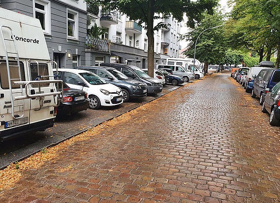 Die OSterbekstraße in Hamburg voll mit dicht an dicht parkenden Autos auf beiden Seiten.