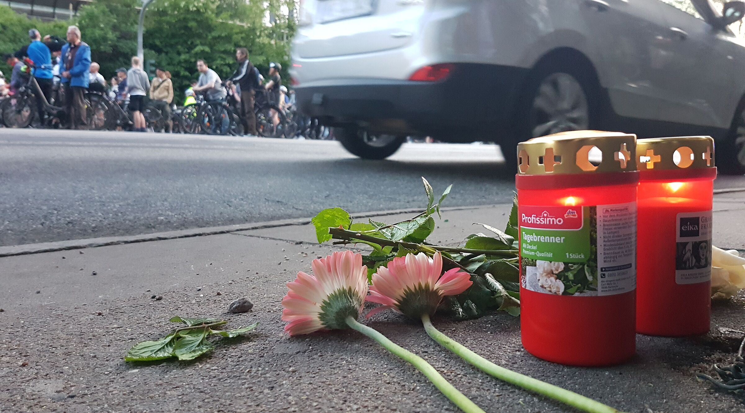 Blumen und Kerzen auf einer Fahrbahn in Gedenken an einen getöteten Radfahrenden