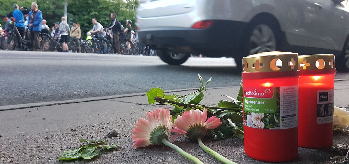 RoS2025 Blumen und Kerzen auf einer Fahrbahn in Gedenken an einen getöteten Radfahrenden
