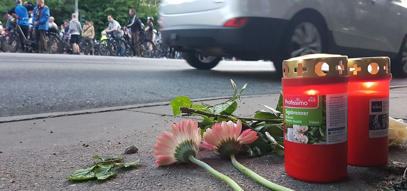 RoS2025 Blumen und Kerzen auf einer Fahrbahn in Gedenken an einen getöteten Radfahrenden