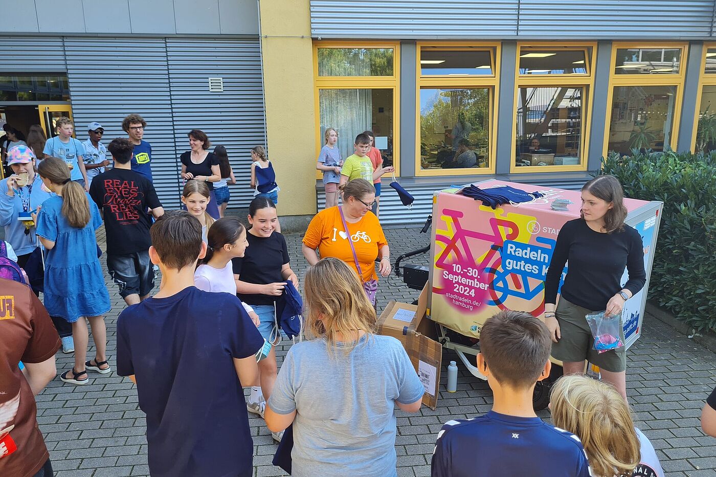 Schüler auf Schulhof erhalten STADTRADELN-Geschenke