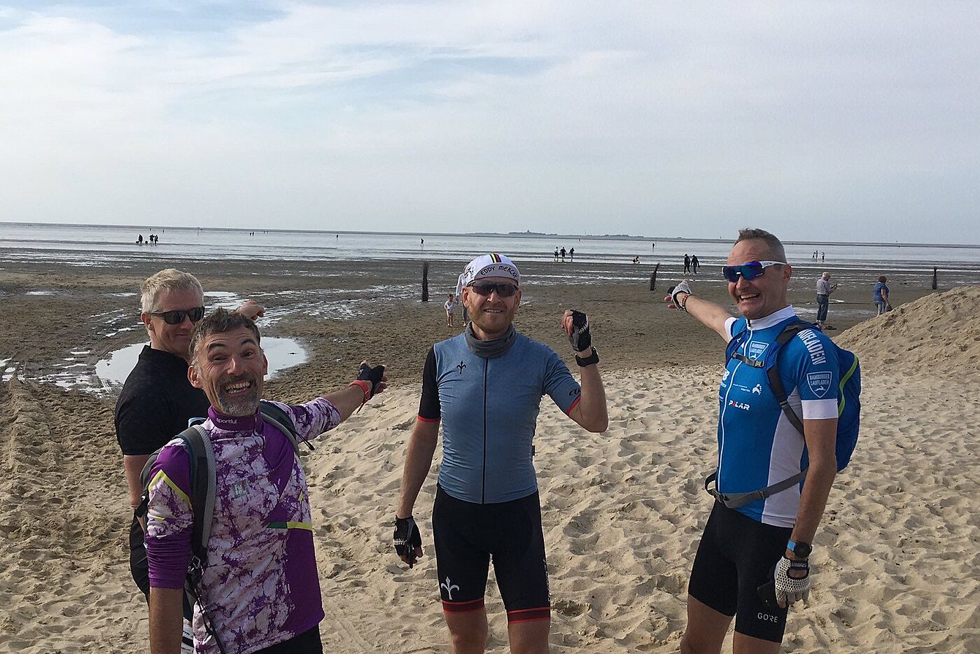 Vier Radfahrende am Strand von Cuxhaven