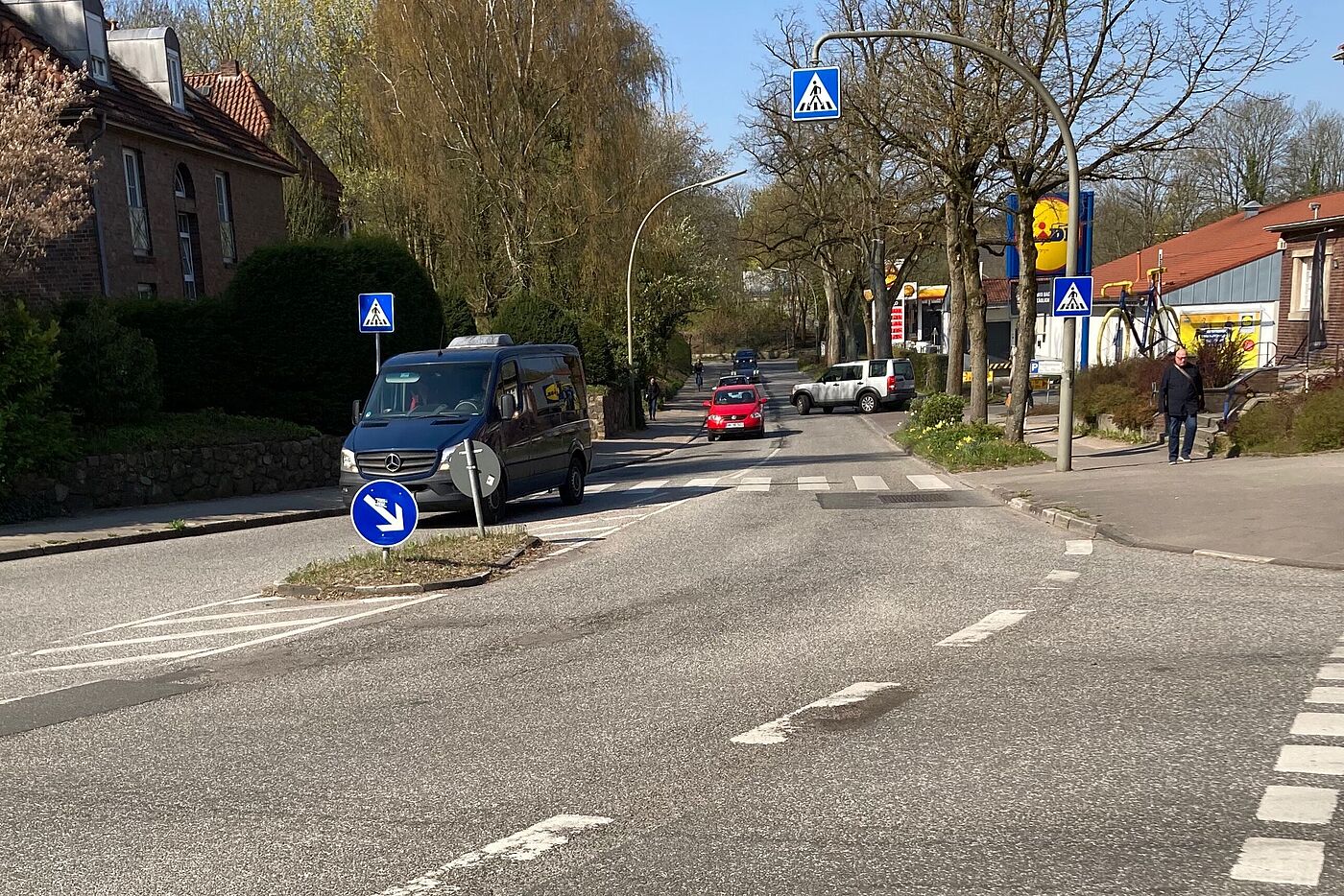 Straßenkreuzung mit relativ viel Autoverkehr auf der Fahrbahn