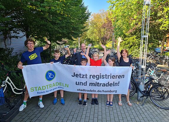 Gruppe hält ein Banner mit STADTRADELN-Aufschrift in die Höhe