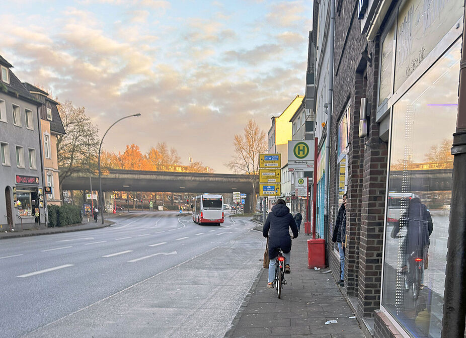 Die Winsener Straße in Harburg. Keine Radverkehrs-Infrsastruktur. eine Radfahrende Person auf dem Gehweg.