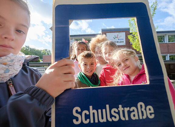 Kinder mit eine Schild für Schulstraßen