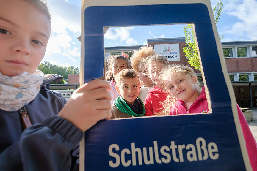 Grundschule Wesperloh: Aktionstag für Einrichtung einer Schulstraße Kinder mit eine Schild für Schulstraßen