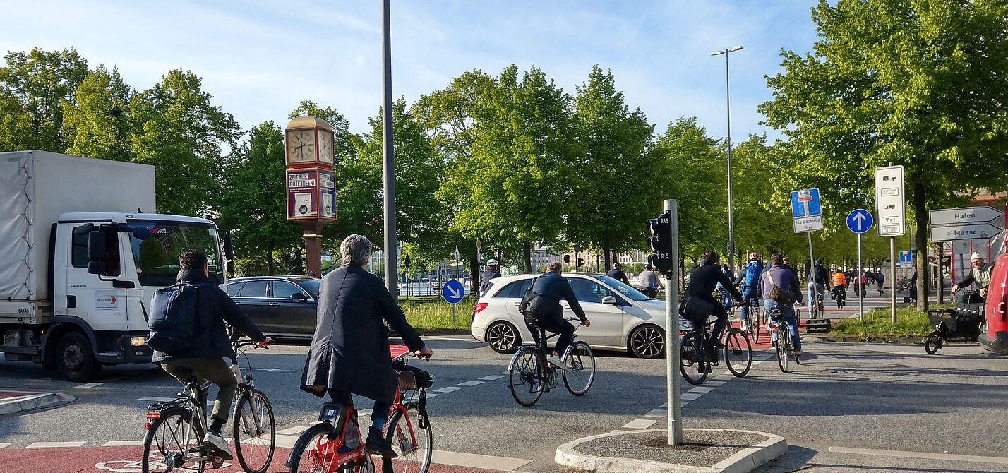 Viele Radfahrende überqueren eine Kreuzung