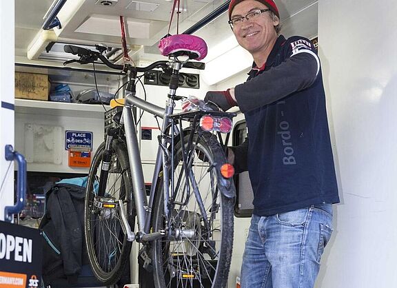 Mann in einem Kastenwagen, Fahrradreparatur