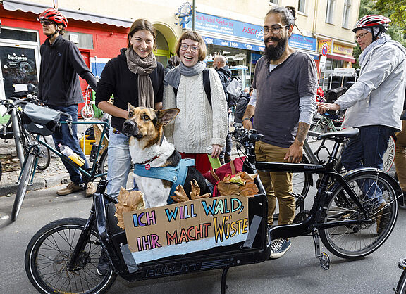Einige junge Menschen stehenum ein Lstenrad herum. Ein Schild mit der Aufschrifft: Ich will Wald - Ihr macht Wüste