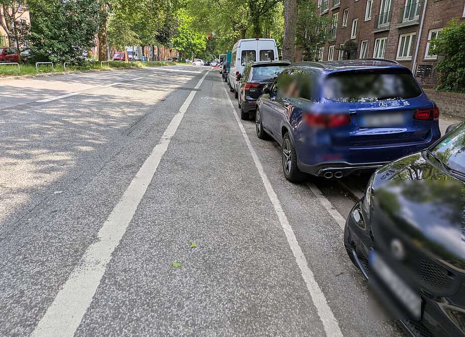 Washingtonallee_18.06.2025 Fahrzeuge parken auf dem Sicherheitstrennstreifen, dadurch ist der Radfahrstreifen direkt in der "Dooring"-Zone.