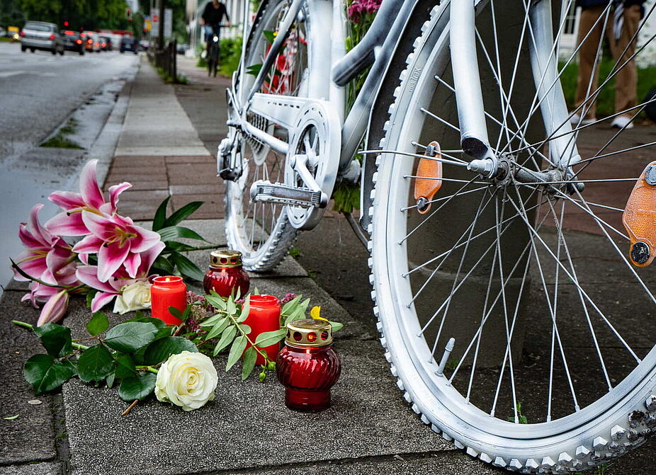 Ghost Bike Ein weiß bemaltes Fahrrad mit Blumen