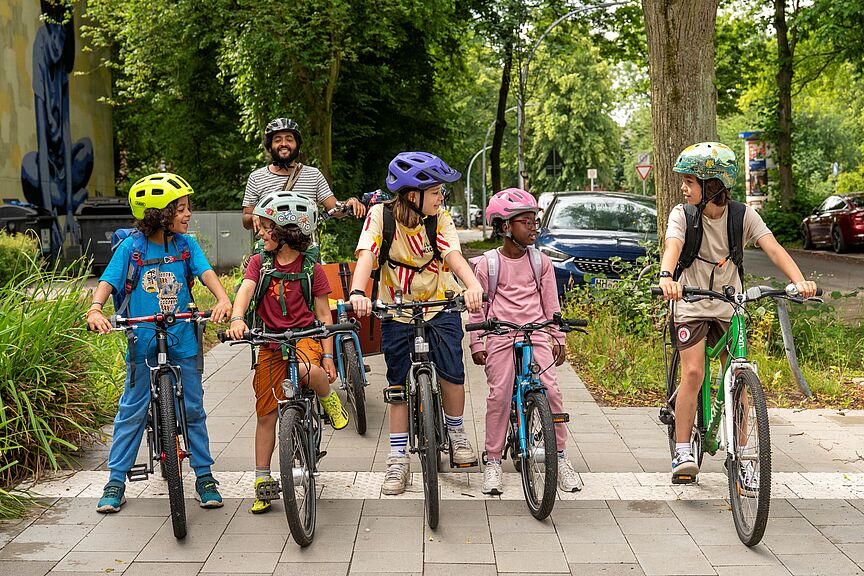 Kindergruppe Schulweg eine Kindergruppe auf Rädern steht auf dem Weg, alle schauen sich an.